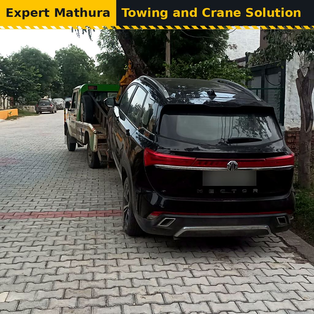 Recovery van towing a black SUV on a residential street, car towing by Expert Mathura Towing and Crane Solution